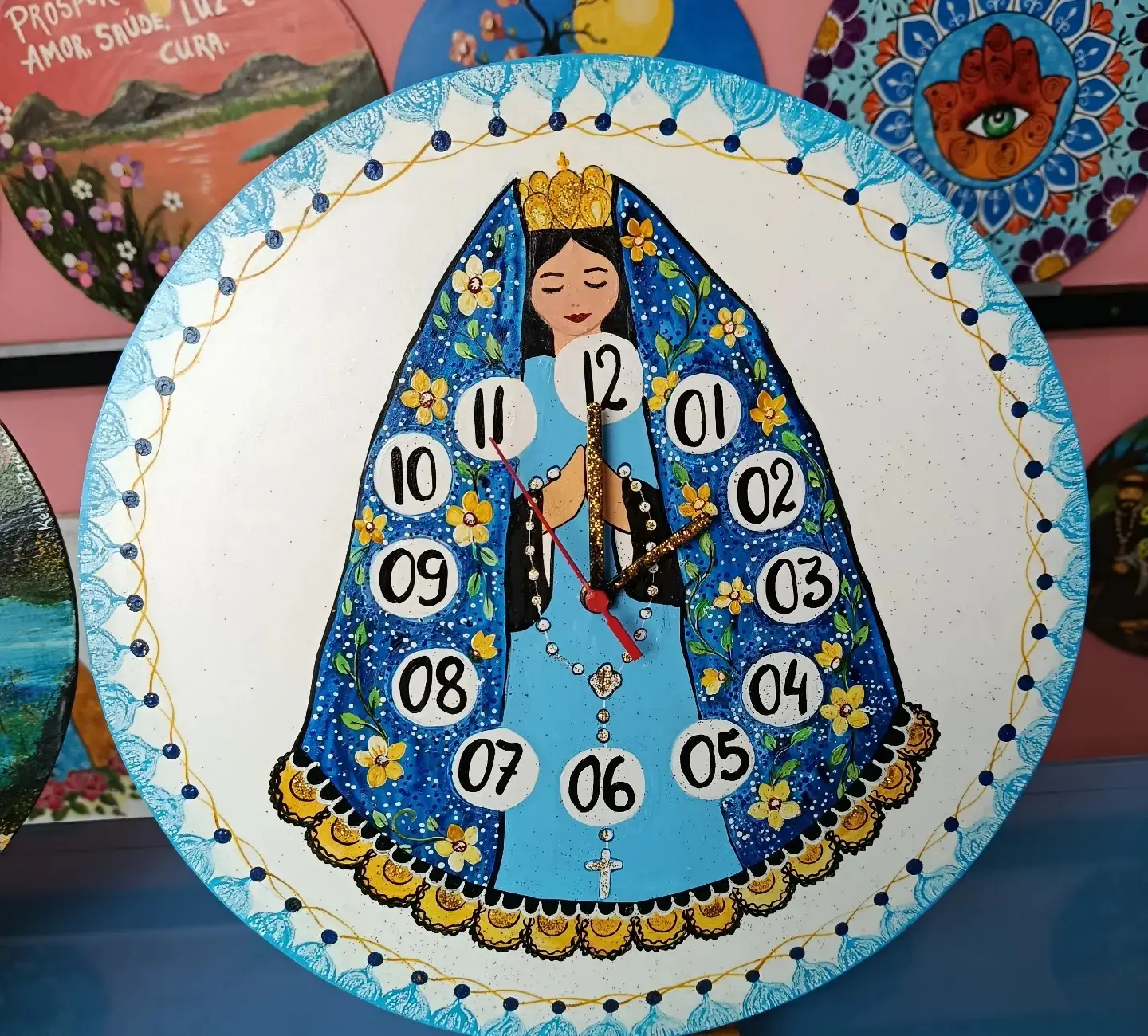 Relógio de madeira pintado com Nossa Senhora em manto azul, todo decorado com pontinhos.